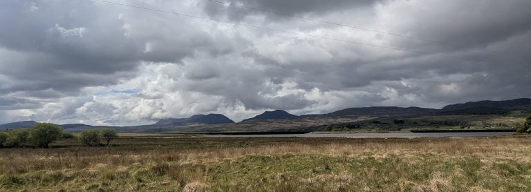 Sweeping panoramic view of the rugged, pathless heather and rocky ridges along the Rhinogydd Traverse in Eryri National Park.