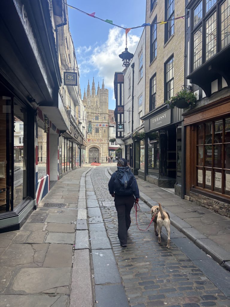 Hikers walking down a quiet Canterbury street back towards the Cathedral to begin their route.