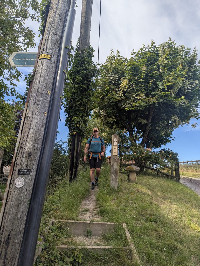 A lush, grassy hiking trail winding through the Kent Downs countryside.