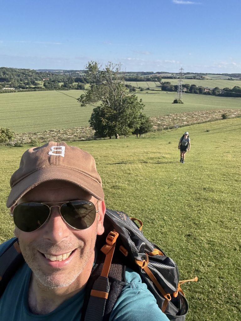 A steep, grassy ascent path pointing directly toward a tall radio mast on top of Etchinghill.