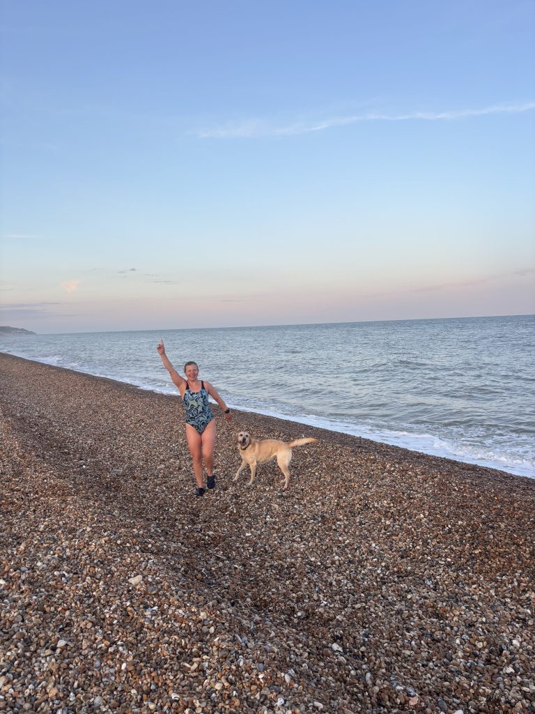 Yellow Labrador cross Poppy splashing happily in the cool, slightly choppy ocean waves.