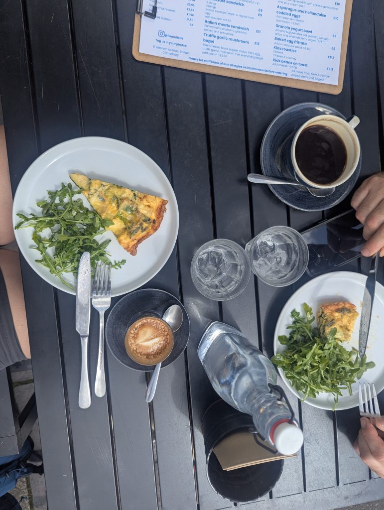 A delicious slice of frittata and a hot cup of coffee resting on a cafe table.