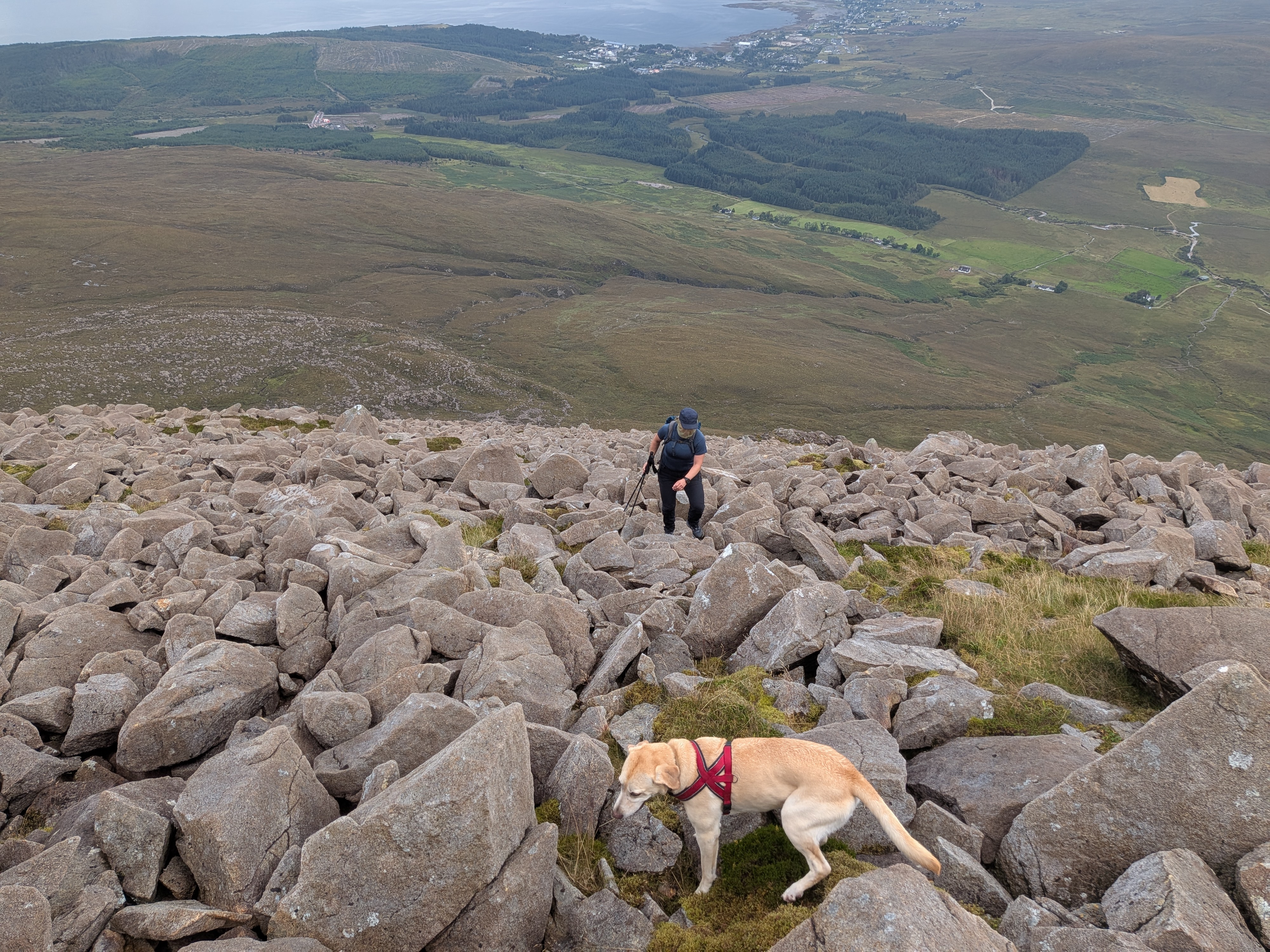 Hiker navigating rocky mountainside boulder field in Scottish Highlands wearing Inov-8 Roclite Pro Mid GTX boots.