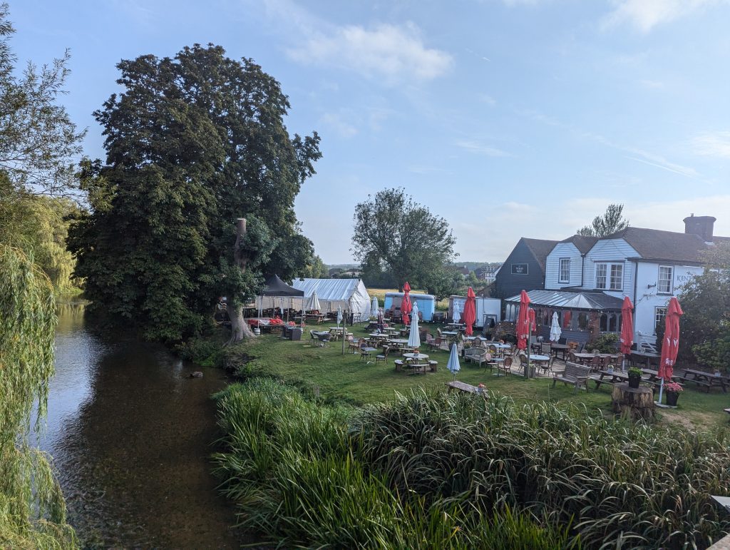 Expansive riverside beer garden at The Tickled Trout pub in Wye, located on the banks of the Great Stour river.